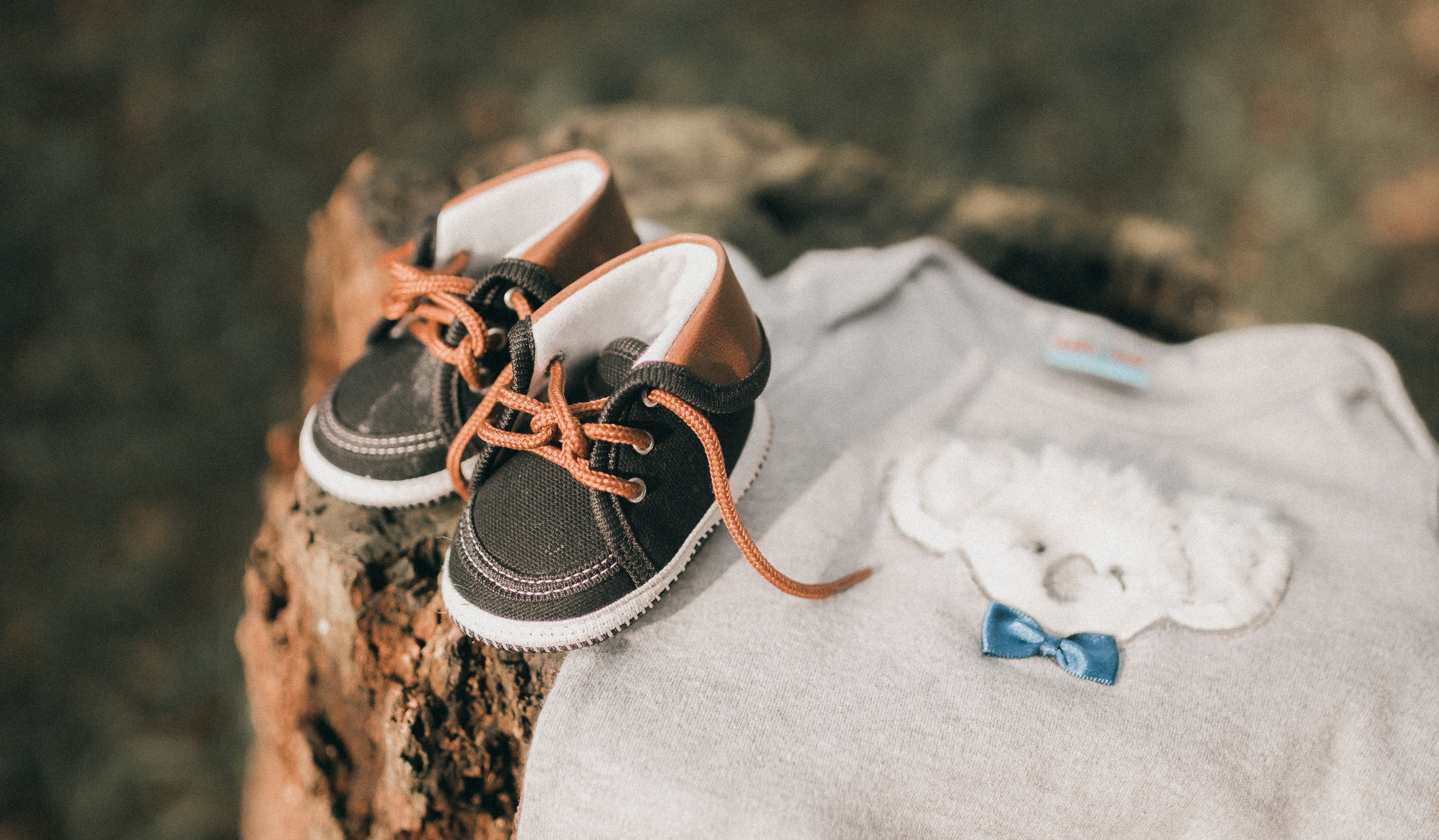 Baby shoes and vest on tree trunk showcasing organic range