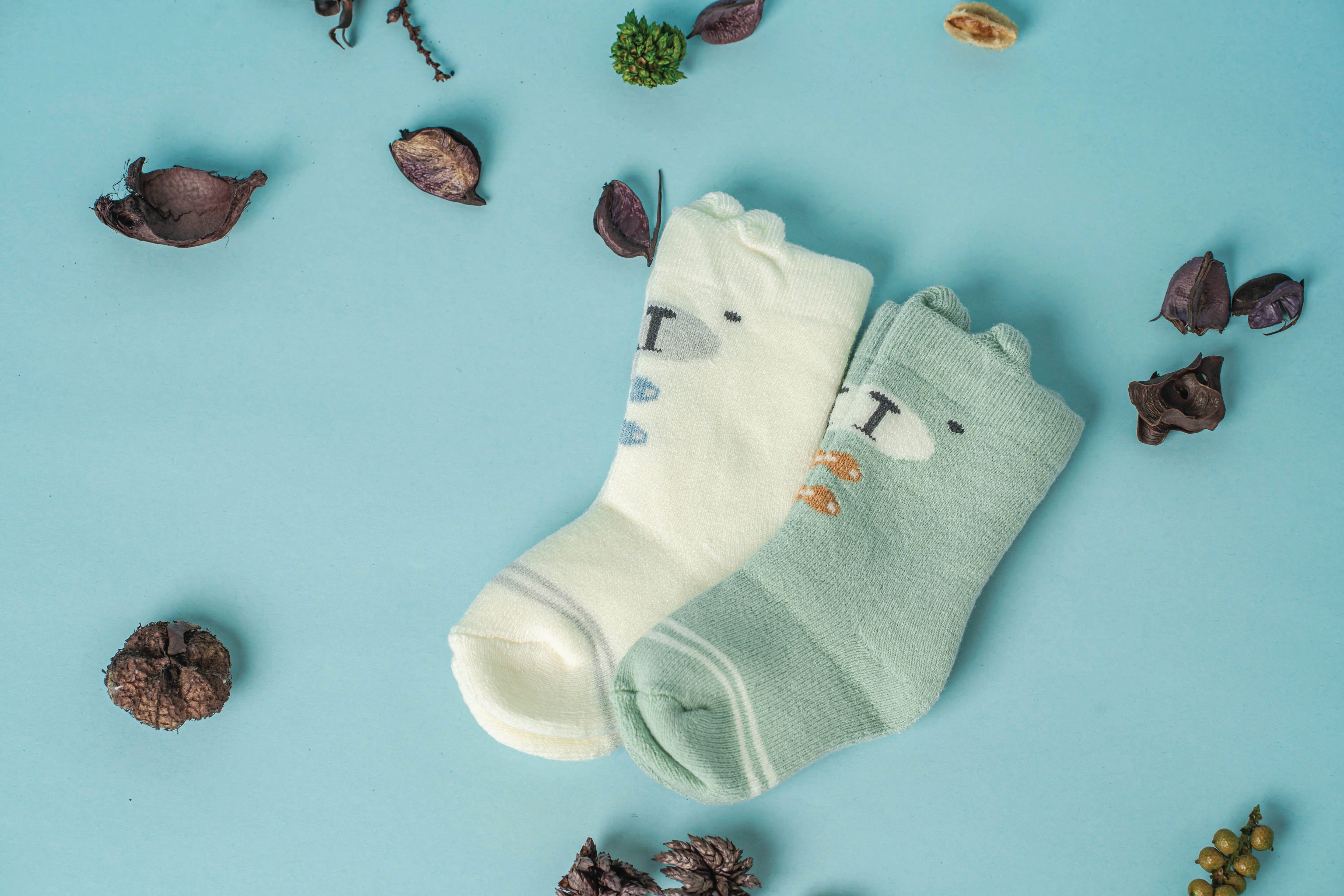 Two socks - one green, one cream for kids and babies